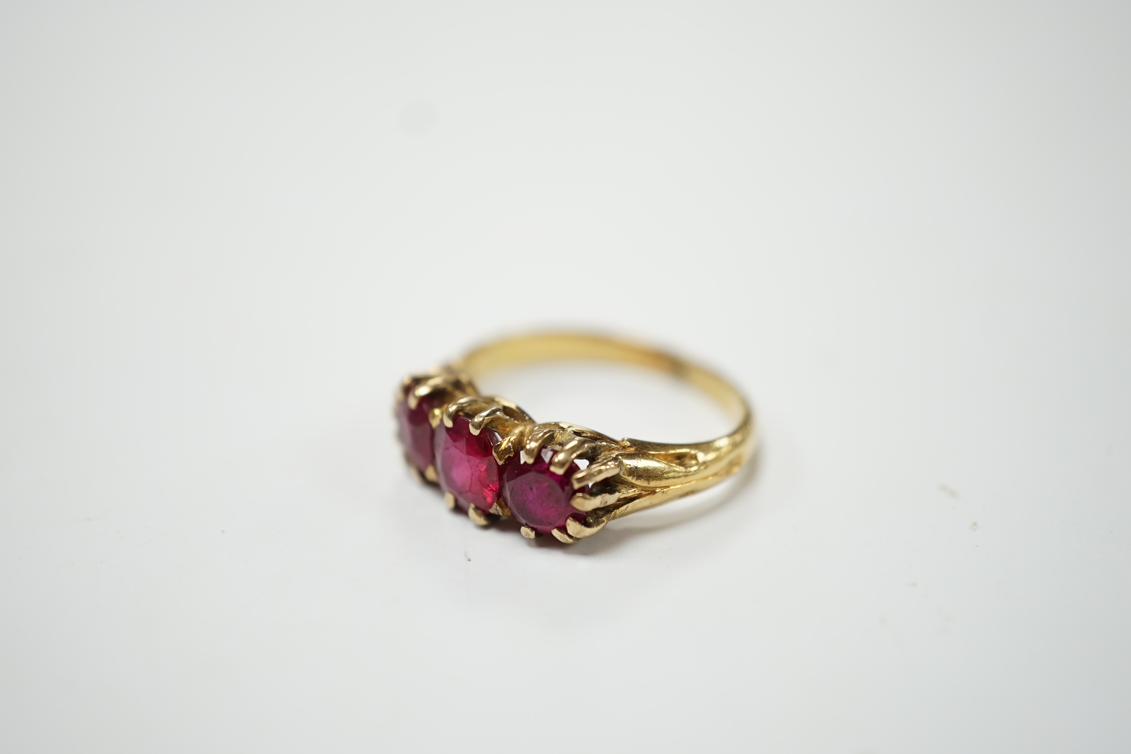 A yellow metal and three stone synthetic ruby set ring, size M, gross weight 4.8 grams. Condition - fair